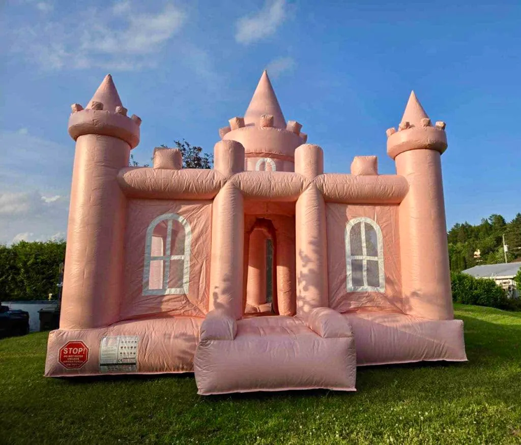 Le château rose vu de biais, sur le gazon, dans la lumière du soir